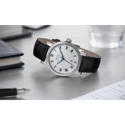 Biała, analogowa tarcza z datownikiem znajdującym się nad godziną szóstą