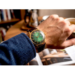 Męski zegarek retro Orient Bambino TAC08002F0 na nadgarstku przy biurku w gabinecie