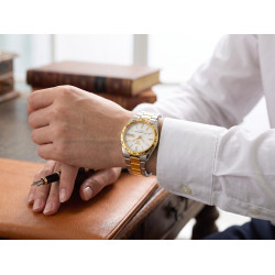 Zegarek Seiko 5 SNKE04K1 na męskim nadgarstku przy starych książkach w bibliotece