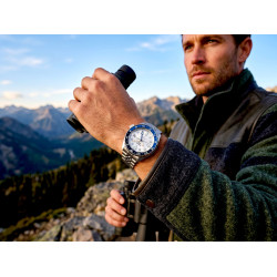 Męski zegarek Seiko 5 Sports GMT SSK033K1 na nadgarstku w górach z lornetką