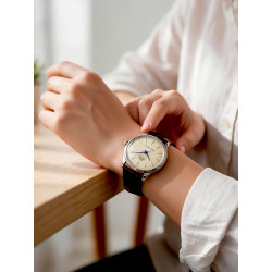 Zegarek unisex Orient Bambino 36 RA-BB0104Y30B na kobiecym nadgarstku przy stole