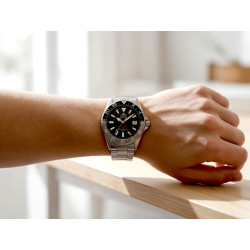 Zegarek Orient Mako GMT RA-BC0001B30B na męskim nadgarstku przy stole