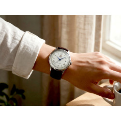 Orient Bambino TAC00009W0 na męskim nadgarstku w lnianej koszuli przy kawie